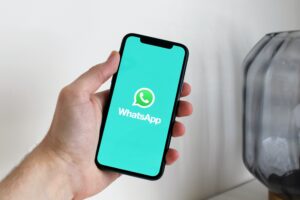 Mão segurando o celular com o whatsapp aberto